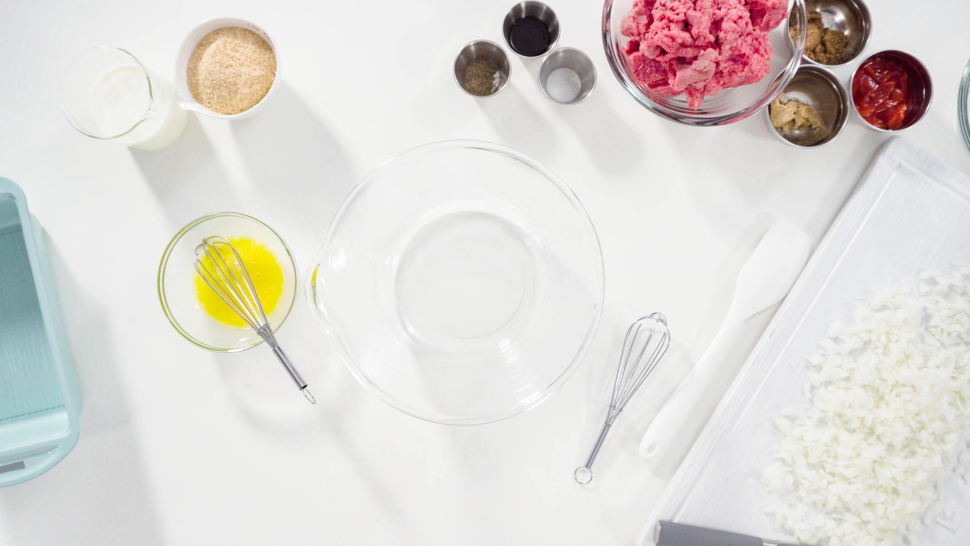 Interior of a pastel-toned culinary studio with wooden worktops